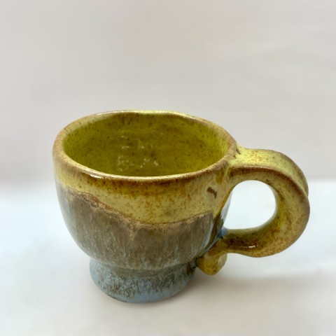 Taza pequeña interior y borde amarillo mono. Exterior azul moteado